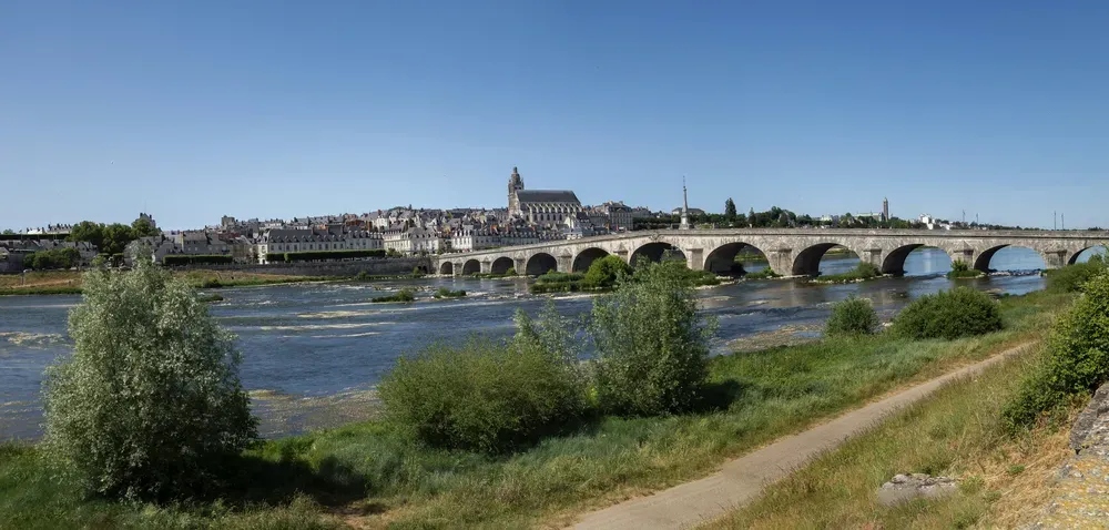 A bridge over the Loire river with a city in the background