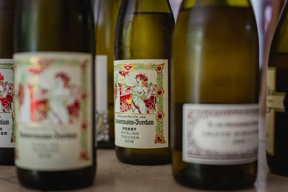 Multiple bottles of Riesling - two are blurry in front, revealing a central non blurry tag