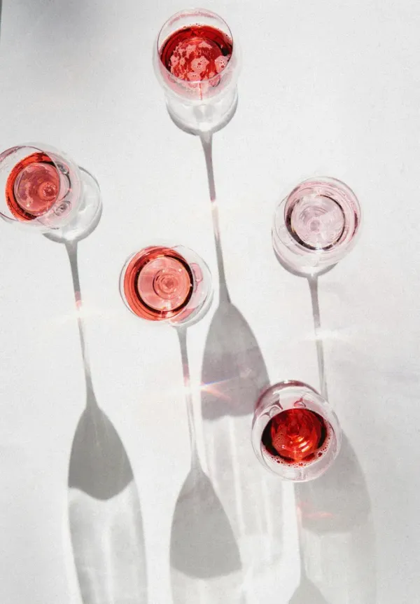 Five glasses of lightly coloured red wine glasses